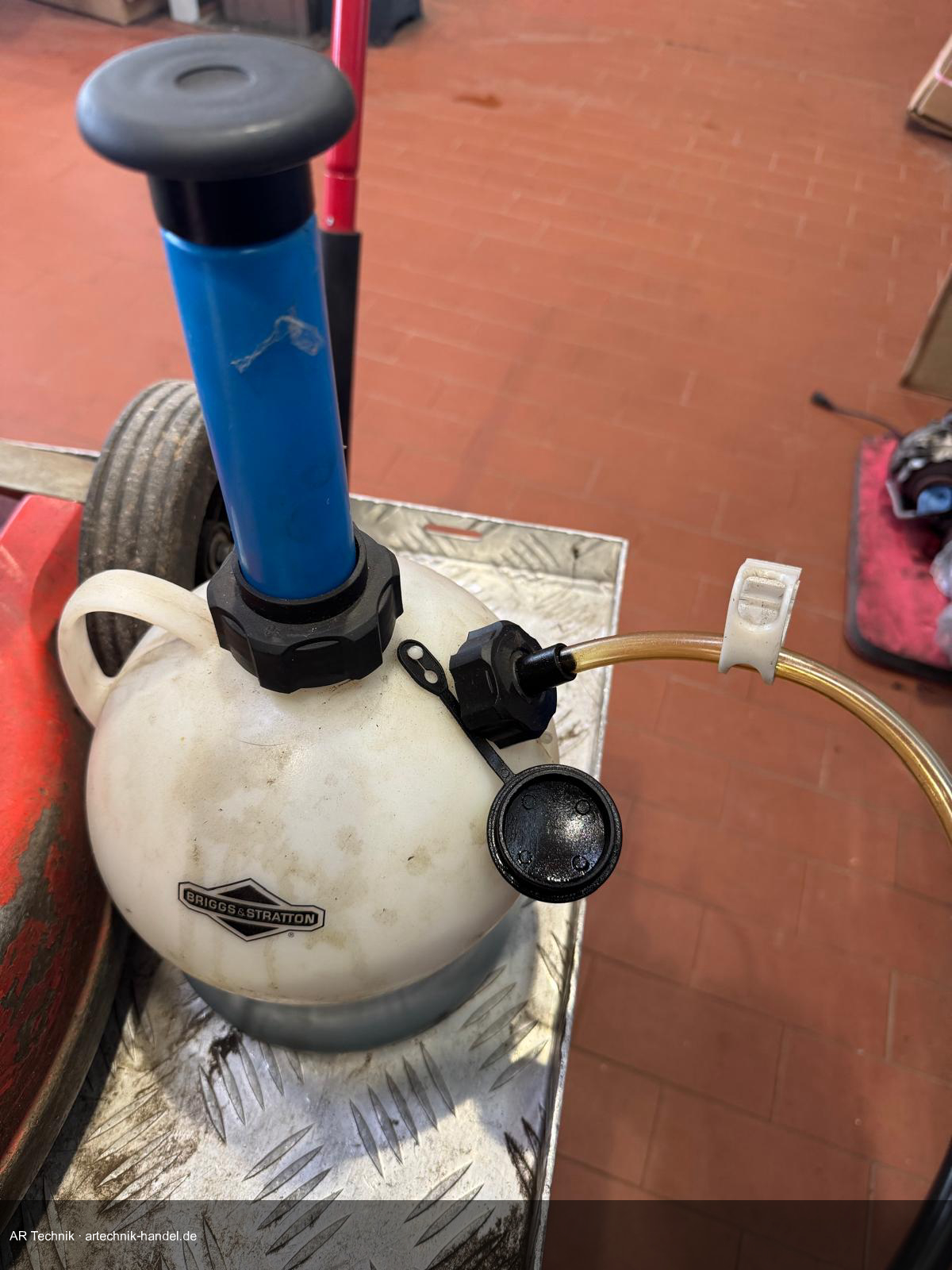 Ölabsaugpumpe mit Briggs & Stratton Auffangkanister – Schlauch wird in die Öleinfüllöffnung eingeführt
