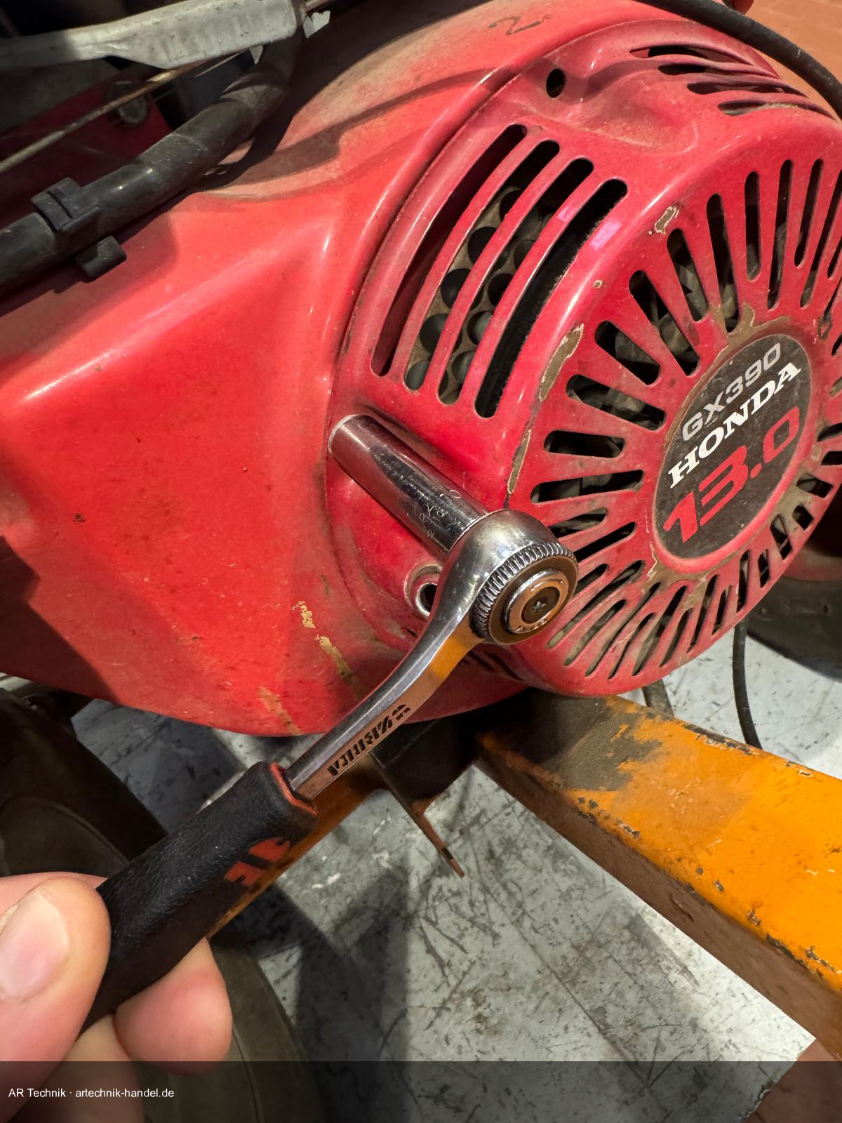 Ratsche löst Schraube am Starterdeckel des Honda GX390