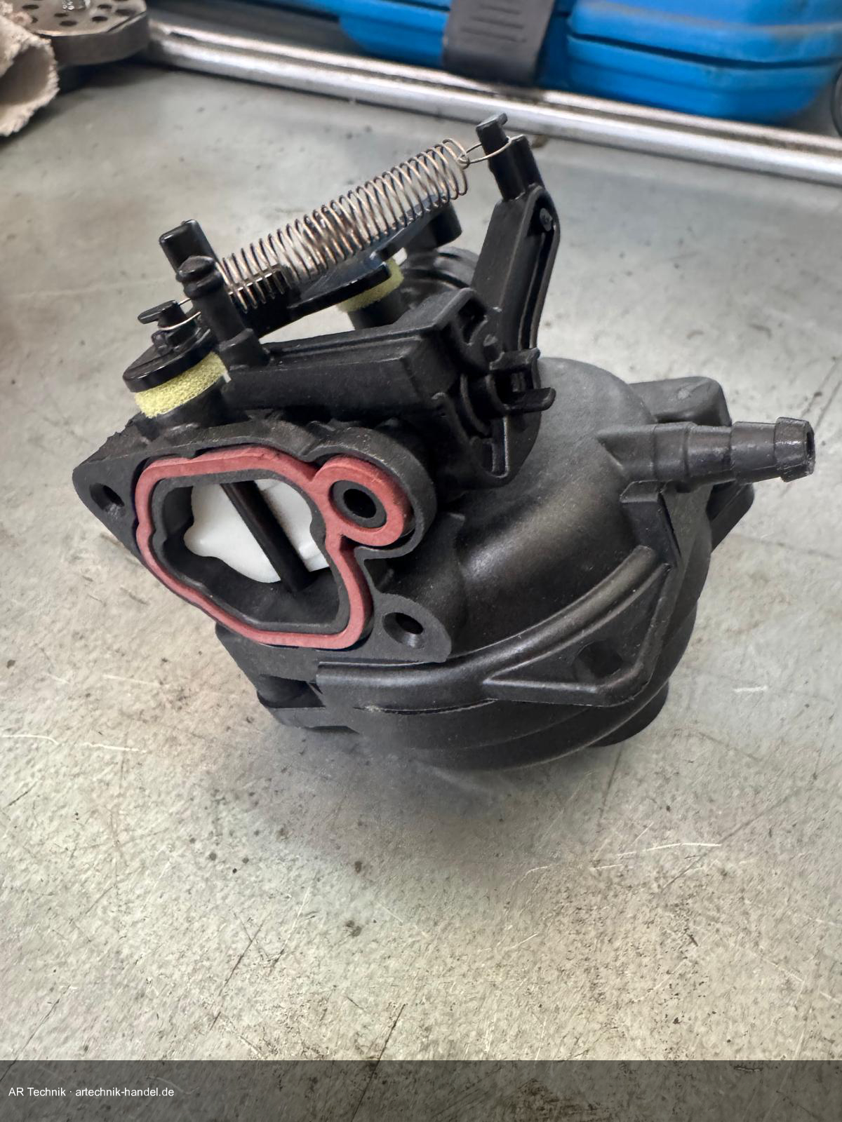 Briggs & Stratton Vergaser ausgebaut auf Werkbank – Einlassdichtung und Chokegestänge sichtbar